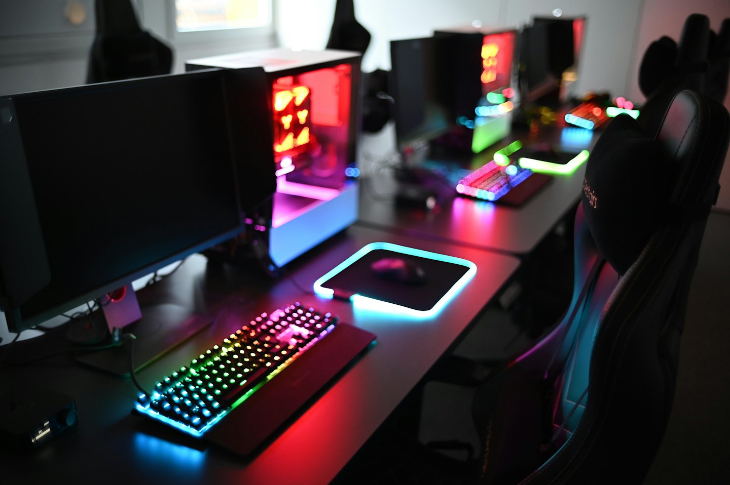 Moderne postazioni di lavoro per computer con componenti RGB luminosi e monitor.